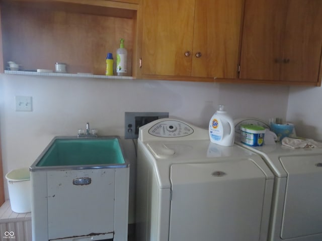 clothes washing area featuring hookup for a washing machine and cabinets