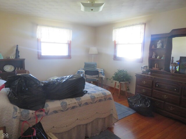 bedroom with light wood finished floors and multiple windows