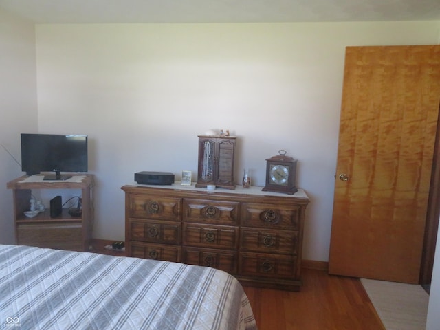 bedroom with baseboards and wood finished floors