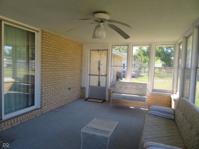 sunroom / solarium with a ceiling fan and a wealth of natural light