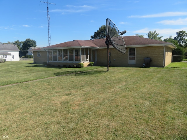 back of property with a lawn and a sunroom