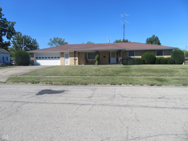 ranch-style house with driveway, an attached garage, and a front yard