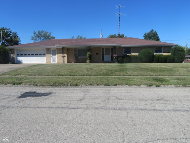 single story home with driveway, an attached garage, and a front yard