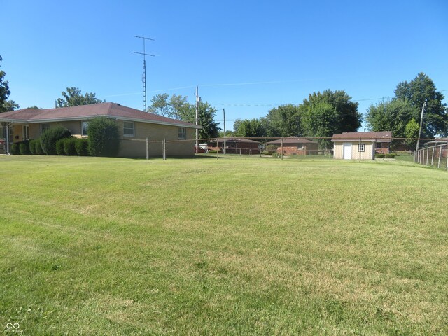 view of yard featuring an outdoor structure, a storage unit, and fence