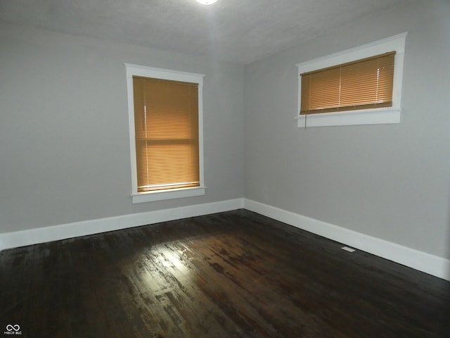 empty room featuring dark hardwood / wood-style flooring and a textured ceiling