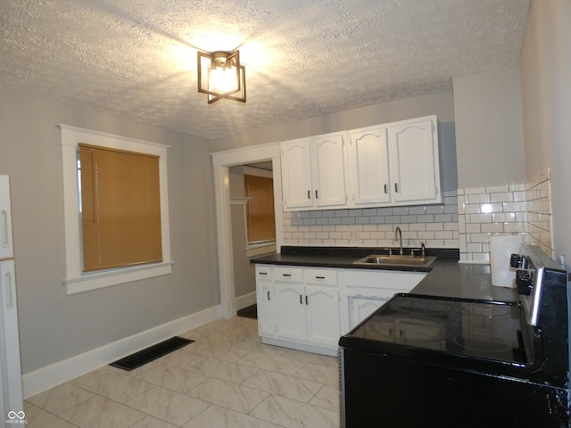 kitchen featuring range with electric stovetop, sink, white cabinets, and tasteful backsplash