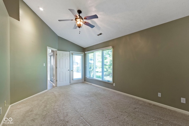 carpeted spare room featuring lofted ceiling, a textured ceiling, and ceiling fan