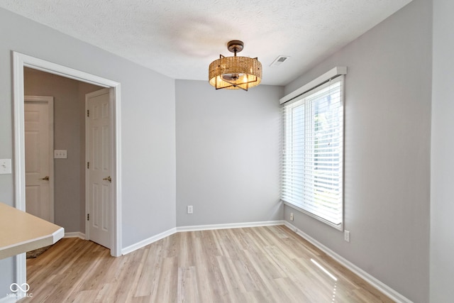 empty room featuring light hardwood / wood-style floors and a textured ceiling