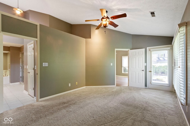 carpeted empty room featuring lofted ceiling, a textured ceiling, and ceiling fan