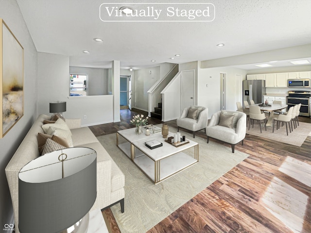 living room with a textured ceiling and light hardwood / wood-style floors