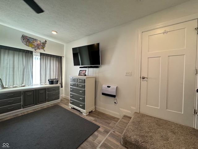 bedroom featuring ceiling fan, dark hardwood / wood-style flooring, and a textured ceiling