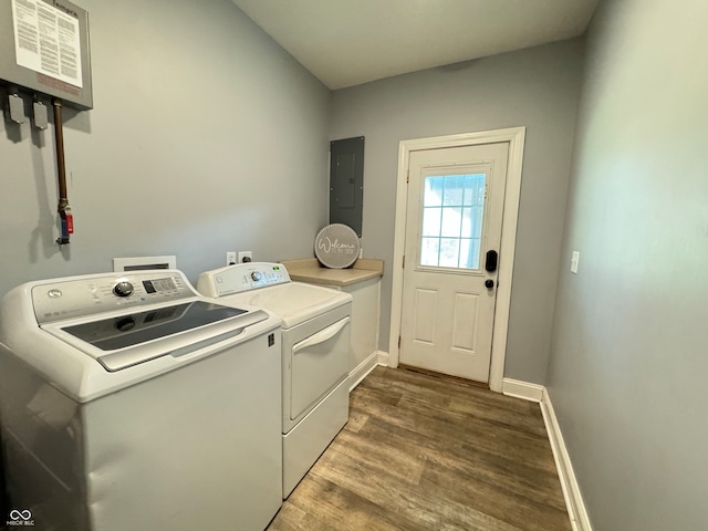 laundry area featuring hardwood / wood-style flooring, cabinets, washer and dryer, and electric panel