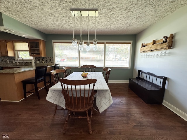 dining space featuring a wealth of natural light, dark hardwood / wood-style flooring, and a textured ceiling