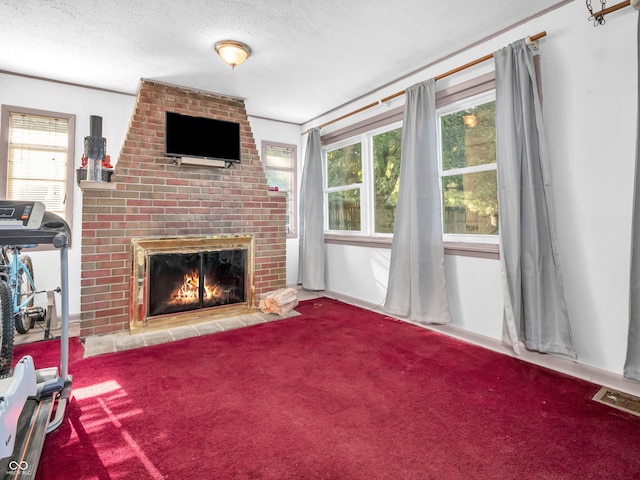 living room with carpet flooring, a fireplace, a wealth of natural light, and a textured ceiling