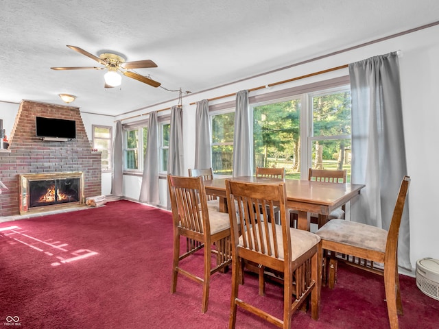 carpeted dining area with ceiling fan, a brick fireplace, and a textured ceiling