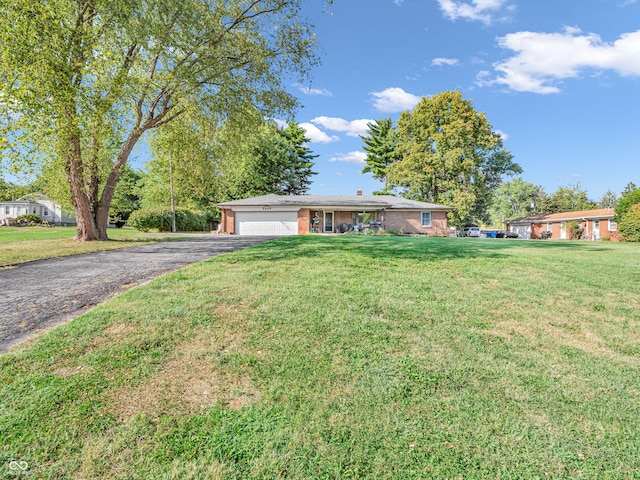 single story home with a front lawn, brick siding, a garage, and driveway