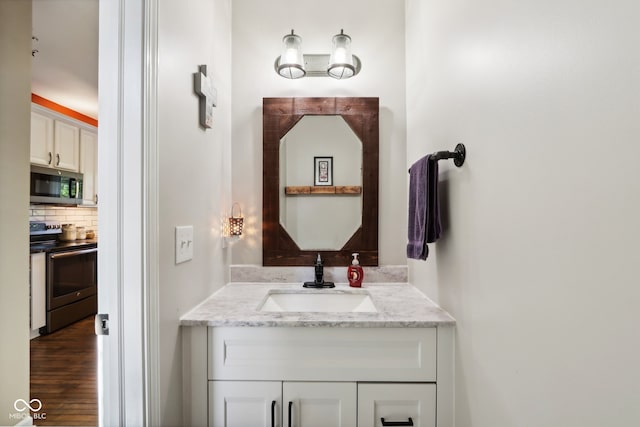 bathroom with vanity, hardwood / wood-style floors, and backsplash