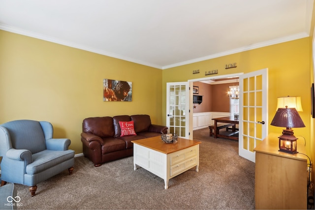 carpeted living room featuring ornamental molding, a chandelier, and french doors