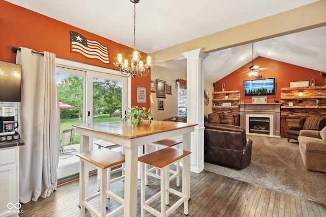 dining room featuring lofted ceiling, dark hardwood / wood-style floors, ceiling fan with notable chandelier, and decorative columns