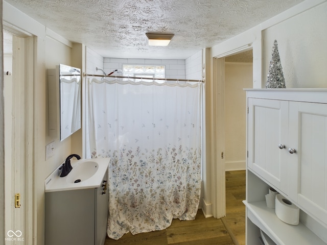 bathroom with a textured ceiling, vanity, a shower with curtain, and hardwood / wood-style floors