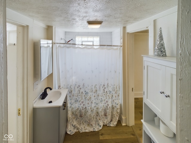 bathroom with a textured ceiling, vanity, a shower with curtain, and hardwood / wood-style floors