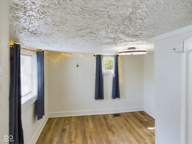 spare room featuring a textured ceiling and hardwood / wood-style floors