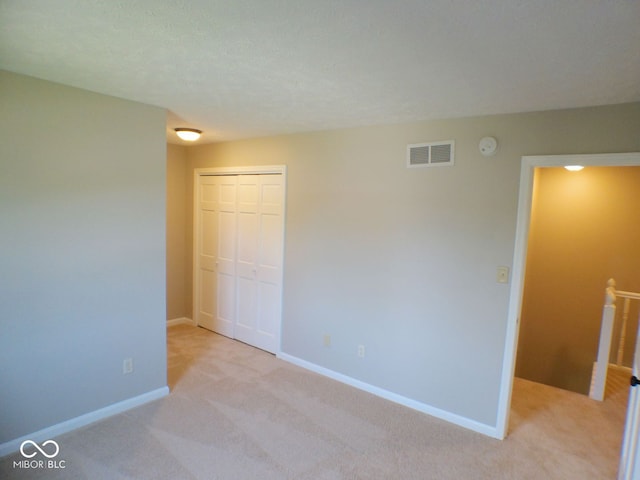 carpeted spare room featuring a textured ceiling