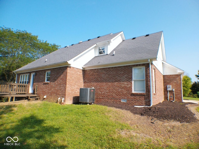 back of house featuring a deck, a lawn, and central air condition unit