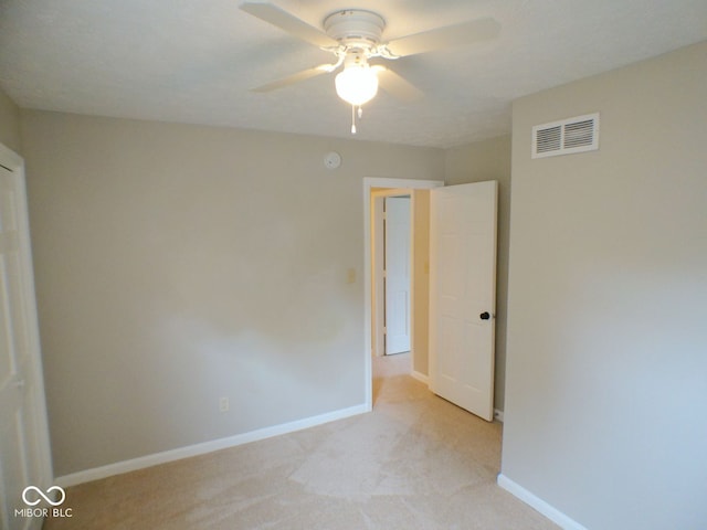 unfurnished bedroom featuring light colored carpet and ceiling fan