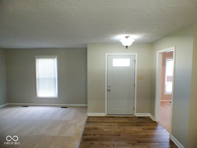 foyer entrance featuring a textured ceiling and hardwood / wood-style flooring