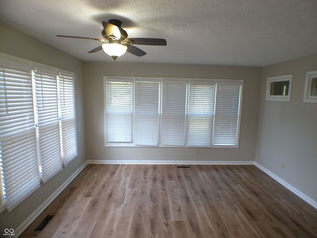 unfurnished room with hardwood / wood-style floors, ceiling fan, and a textured ceiling