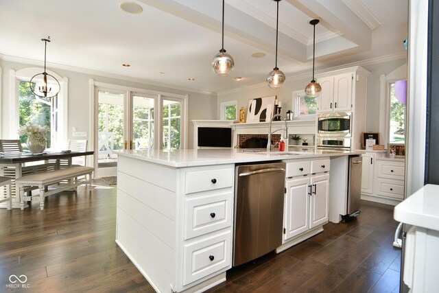 kitchen featuring ornamental molding, dark hardwood / wood-style flooring, a healthy amount of sunlight, and a center island with sink