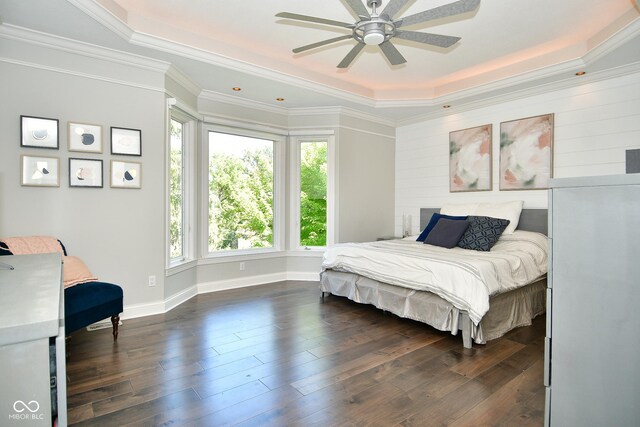 bedroom with dark wood-type flooring, ceiling fan, a raised ceiling, and crown molding