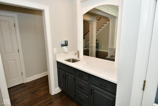 bathroom with decorative columns, wood-type flooring, and vanity