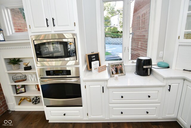 kitchen featuring dark hardwood / wood-style floors, appliances with stainless steel finishes, and white cabinetry