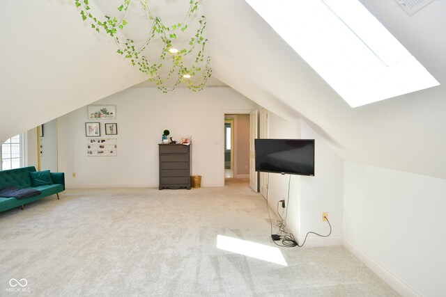 additional living space featuring vaulted ceiling with skylight and light carpet