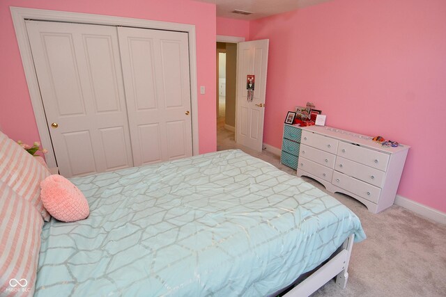 bedroom with light colored carpet and a closet