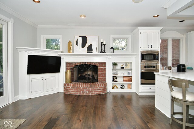 living room with crown molding, dark hardwood / wood-style floors, and a brick fireplace