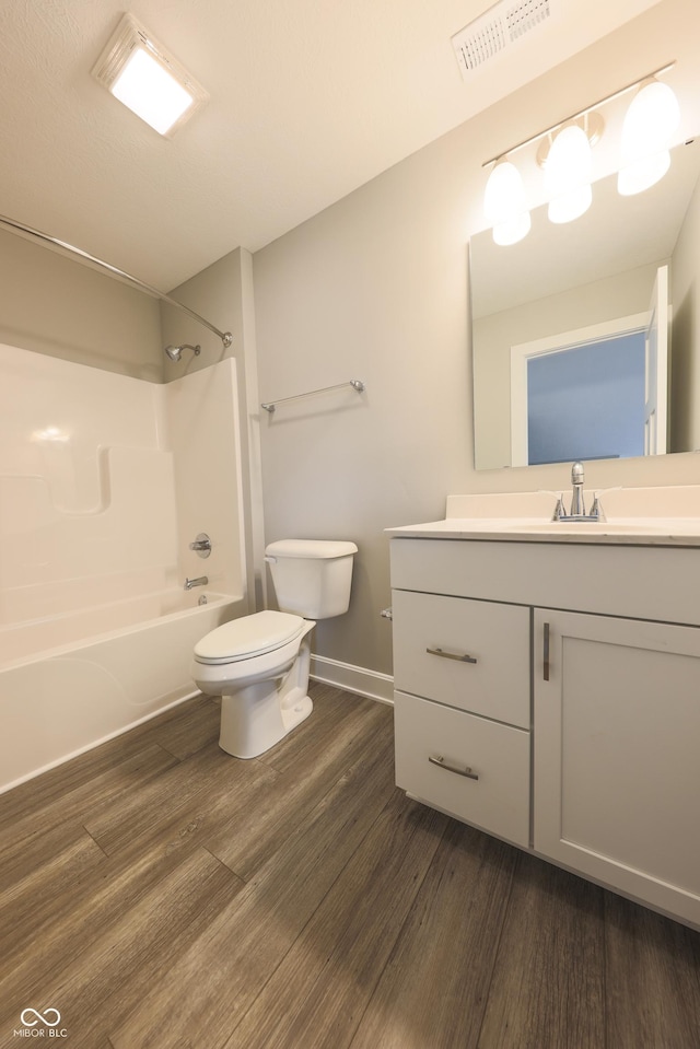 full bathroom with shower / tub combination, vanity, hardwood / wood-style flooring, and toilet