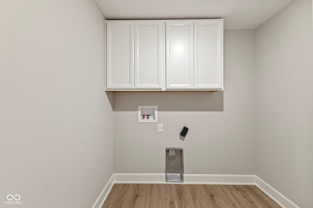 laundry area with cabinets, light hardwood / wood-style floors, and washer hookup