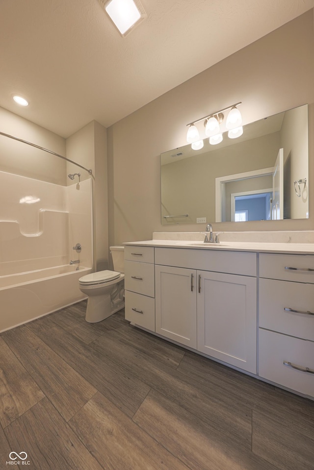 full bathroom featuring toilet, hardwood / wood-style floors, vanity, and tub / shower combination