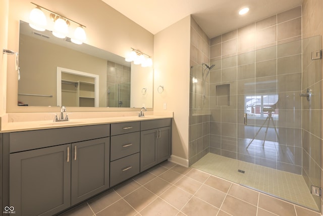 bathroom with tile patterned flooring, vanity, and a shower with door