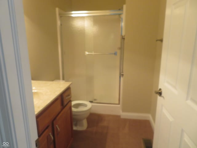 bathroom with a shower with shower door, toilet, and vanity