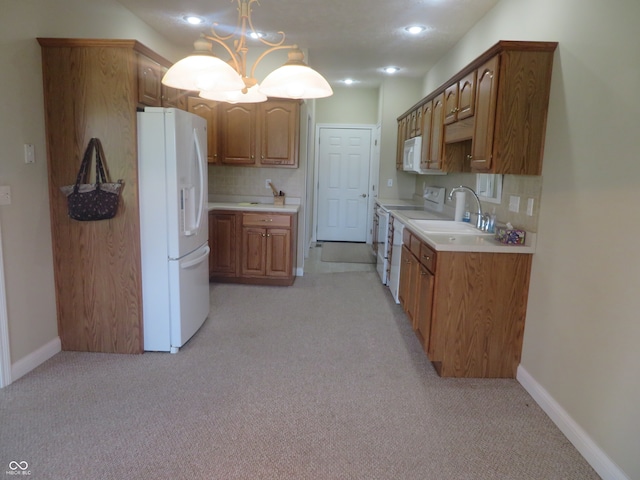 kitchen featuring decorative light fixtures, white appliances, light colored carpet, a chandelier, and sink