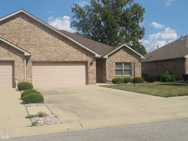 ranch-style house featuring a garage and a front lawn