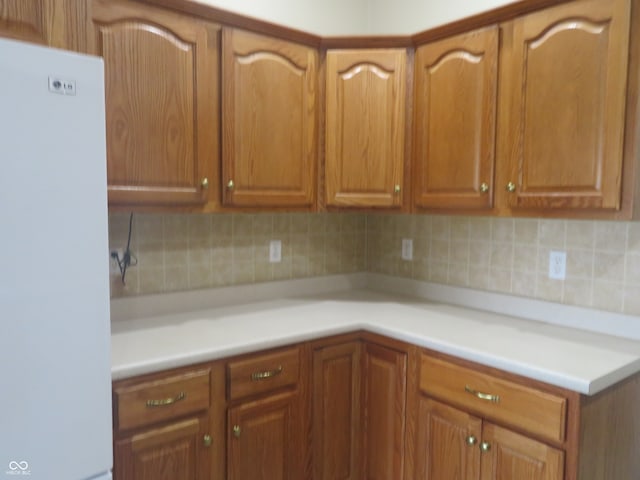 kitchen featuring white fridge and decorative backsplash