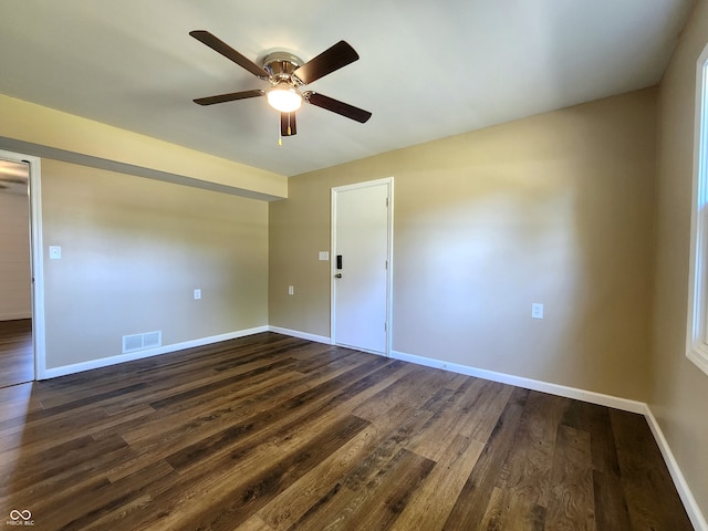 empty room with ceiling fan and dark hardwood / wood-style flooring