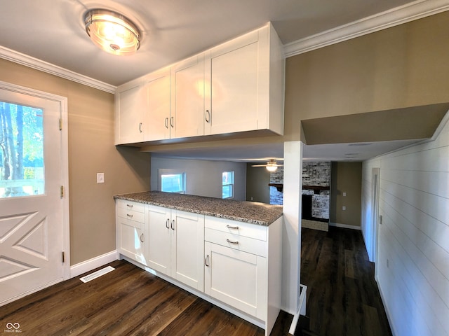 kitchen featuring white cabinets, dark hardwood / wood-style floors, and a brick fireplace