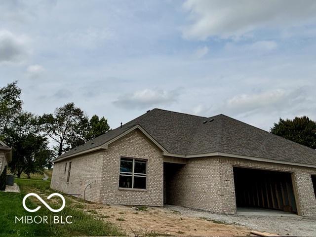 view of front of property featuring driveway, an attached garage, and brick siding