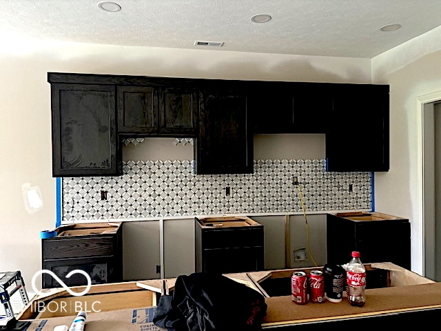 kitchen with a textured ceiling and tasteful backsplash